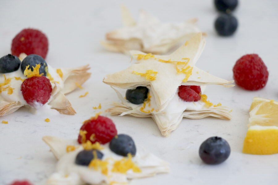 Lemon stars made from puff pastry topped with berries and lemon zest.